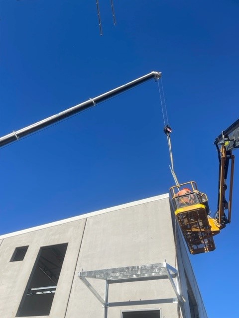 Craning 2.3m lightning mast into place Sydney Airport 33kV building